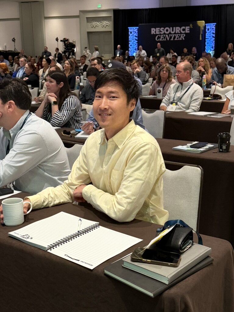Smiling HTM member in a yellow shirt at a How To Manage A Small Law Firm event