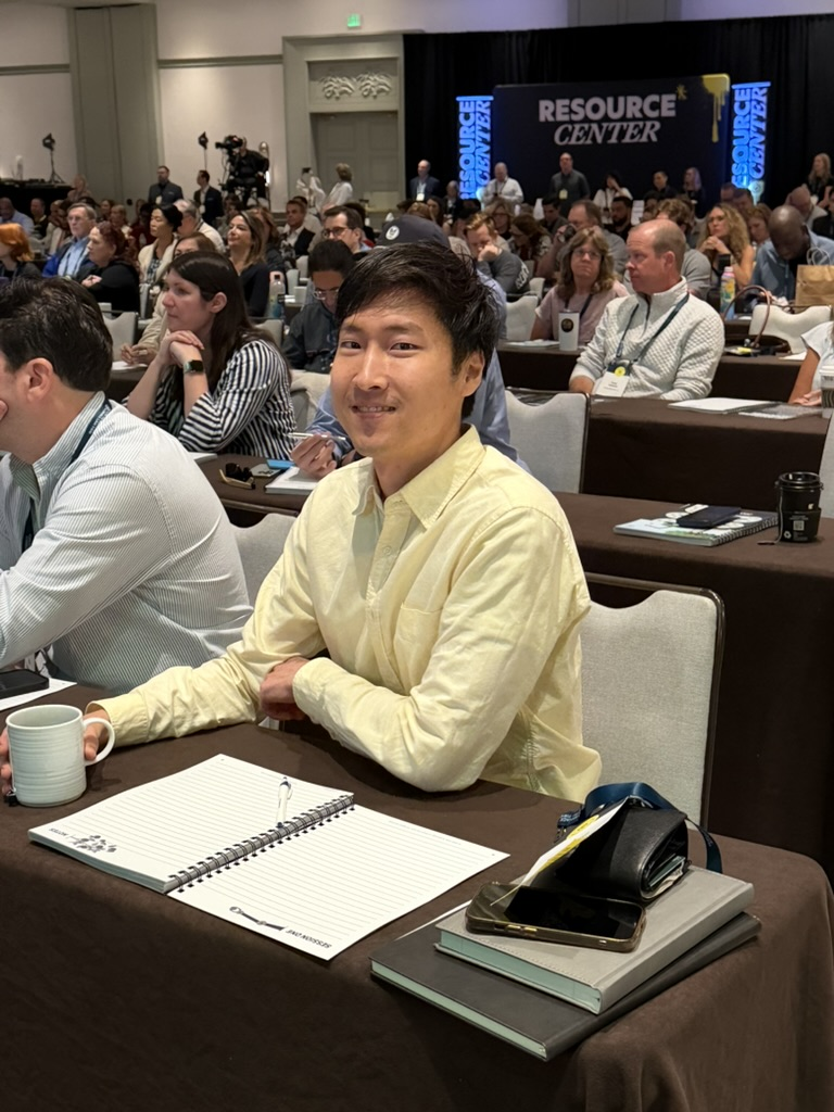 Smiling HTM member in a yellow shirt at a How To Manage A Small Law Firm event