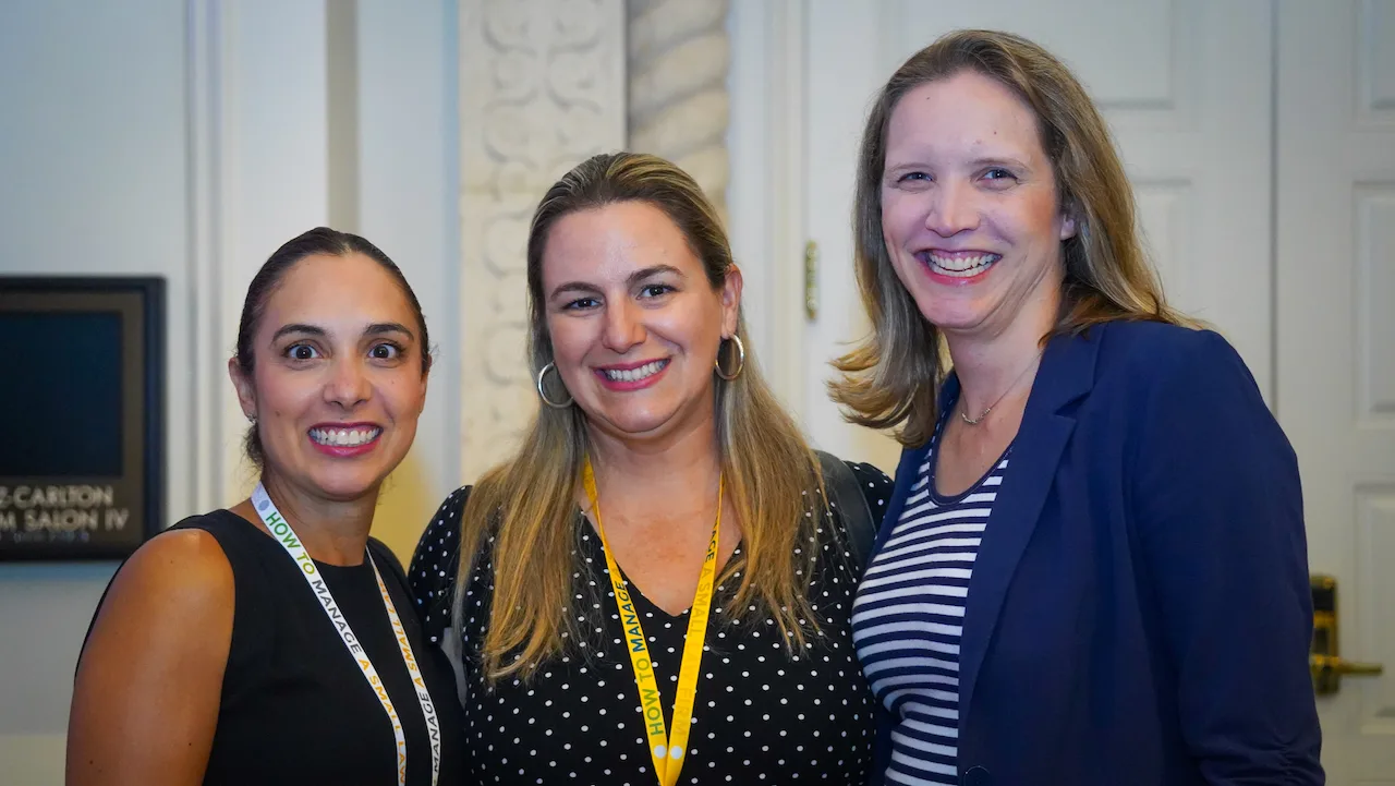 Three HTM members smiling together between sessions.